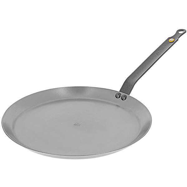 A close-up of a de Buyer carbon steel crepe pan with a handle.