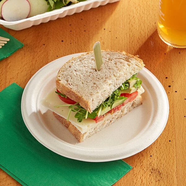 A sandwich on an EcoChoice natural bagasse plate with a salad and a drink.