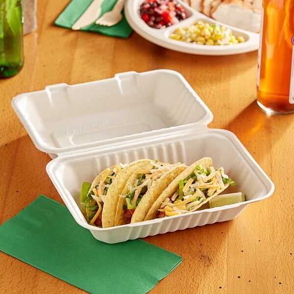 A white EcoChoice bagasse take-out container with tacos on a table.