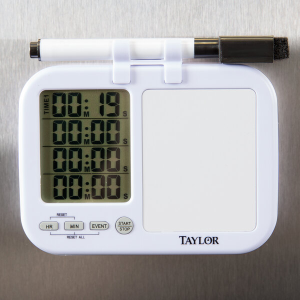 A white Taylor digital kitchen timer with a black dry erase pen holder.