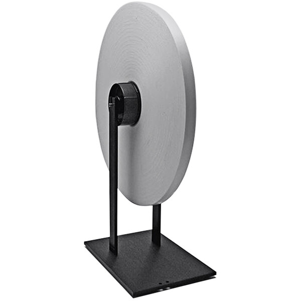 A Start International reel stand with metal legs holding a circular paper roll.