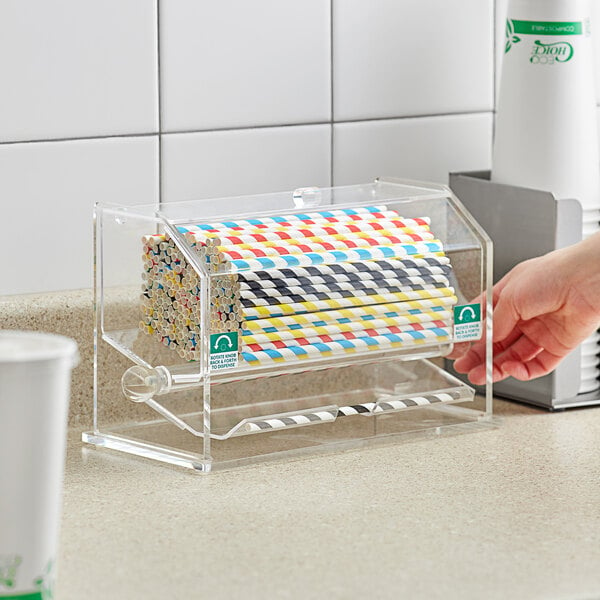 A clear acrylic straw dispenser holding unwrapped straws.
