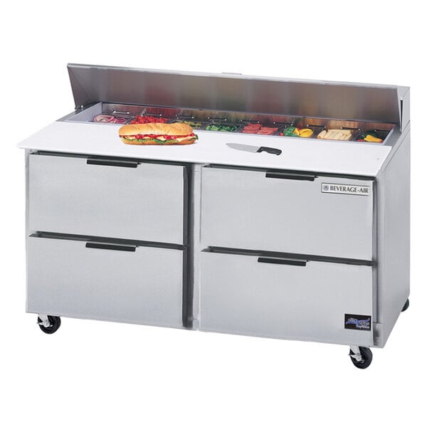 A Beverage-Air stainless steel refrigerated sandwich prep table with trays of sandwiches on top.