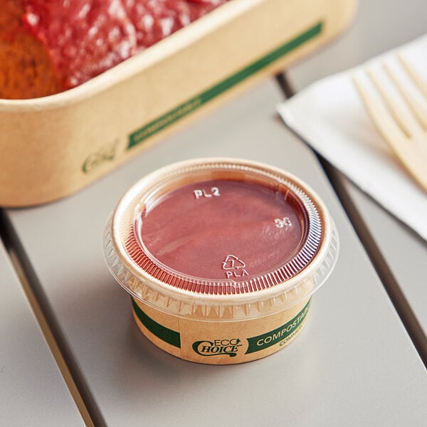 A container of food with a EcoChoice compostable PLA lid on a table.