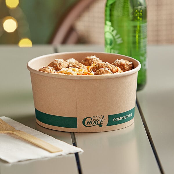 A bowl of food with meatballs and cheese in an EcoChoice round Kraft take-out container on a table.