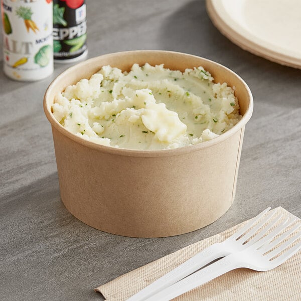 A Choice paper container of mashed potatoes with a fork.