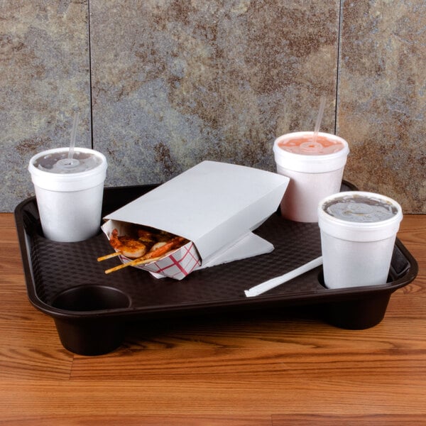 A brown GET polypropylene fast food tray with three drinks and food in containers on it.