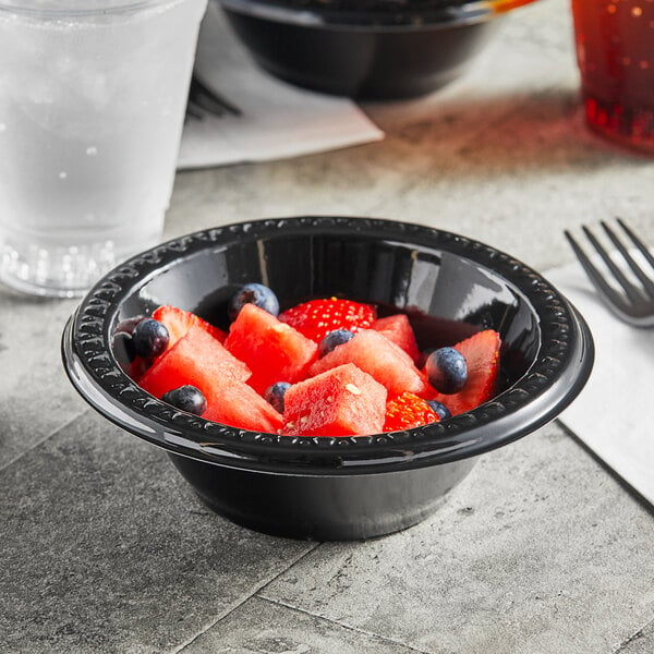 A bowl of watermelon and blueberries in a Huhtamaki Chinet black plastic bowl.