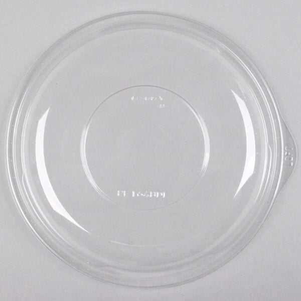 A clear plastic lid with a small hole covering a white circle.