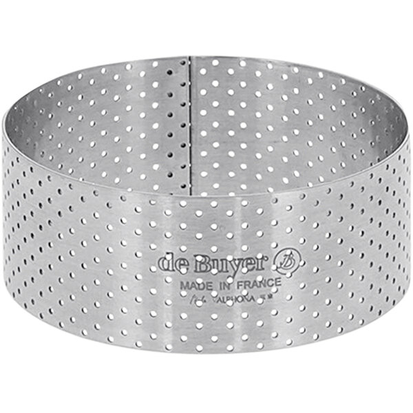 A stainless steel circular tart ring with perforations.