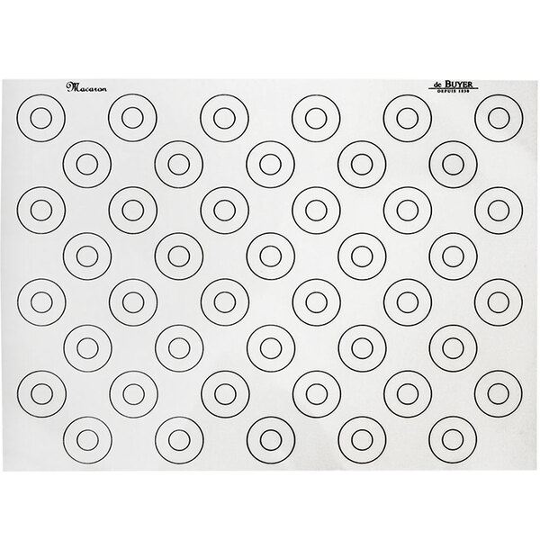 A white silicone baking mat with black circles for macarons.