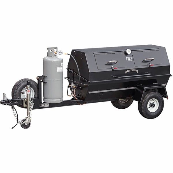 A large black Meadow Creek gas pig roaster on a grey trailer with a propane tank.