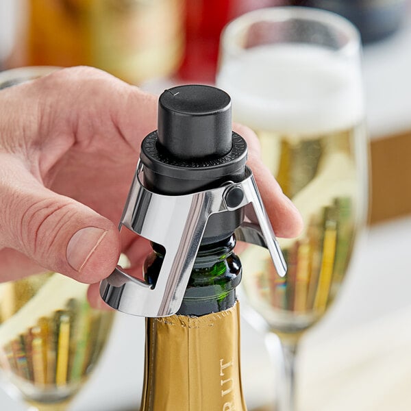 An Acopa Plastic pump champagne bottle stopper being used to open a bottle of champagne.