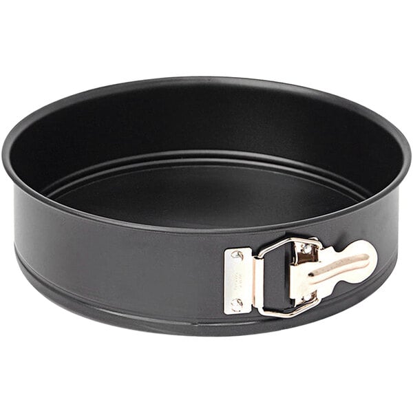 A round black de Buyer steel cake pan with a metal handle.