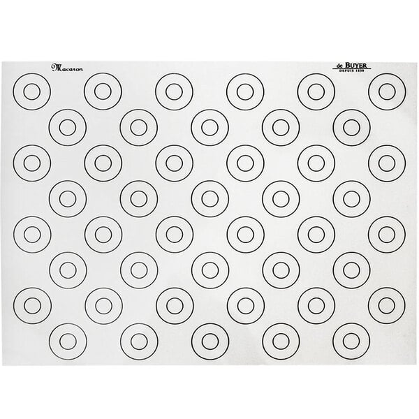 A white silicone baking mat with black circles for macarons.