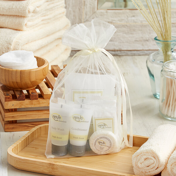 A bag of Novo Essentials hotel toiletries and towels on a tray.