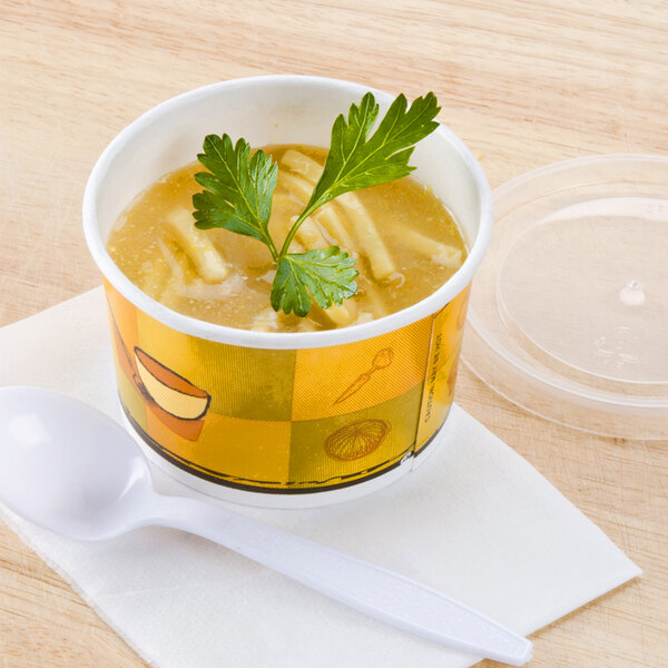 A Huhtamaki paper cup of soup with a spoon and plastic lid.