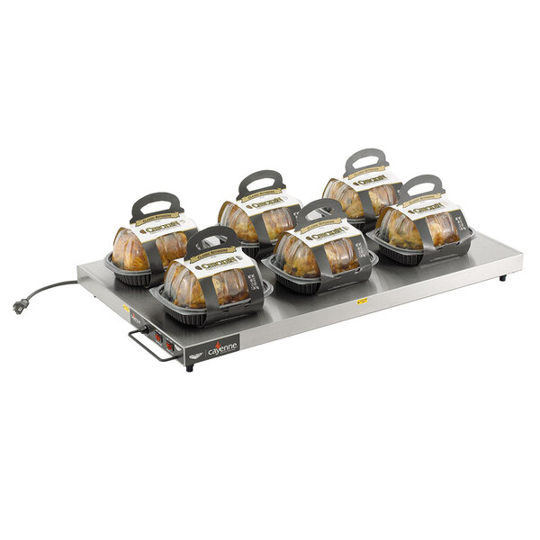 A Vollrath 60" heated shelf warmer with six trays of chicken on a table.