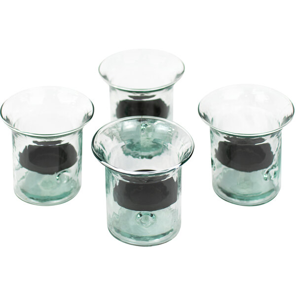 A set of four small clear glass cylindrical candle holders with black metal inserts.