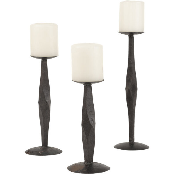 A group of three black metal pillar candle holders.