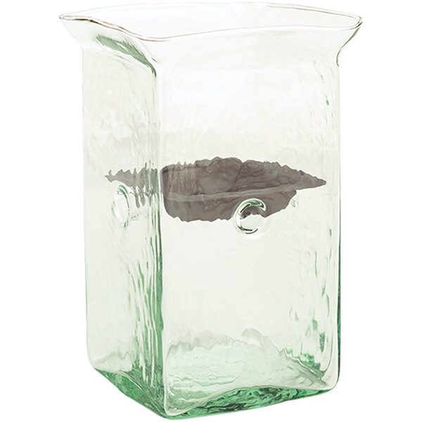 A green glass container with a rustic metal insert.