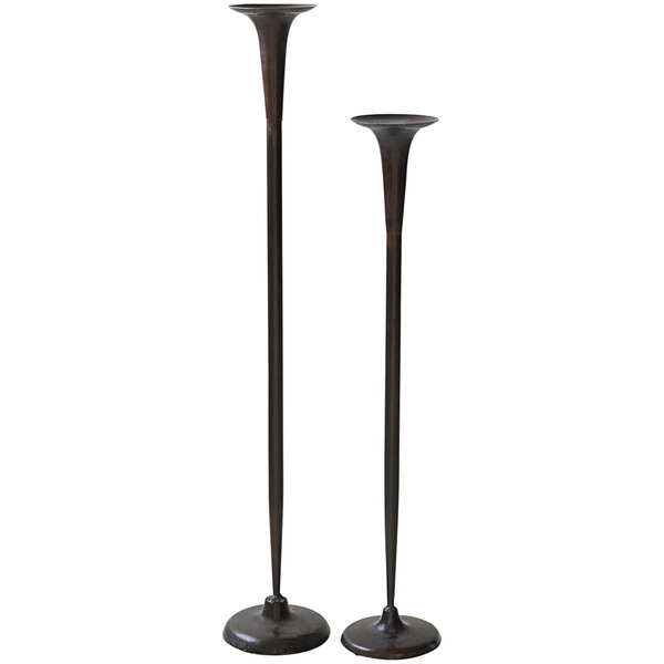 Two tall metal pillar candle holders with metal bases.