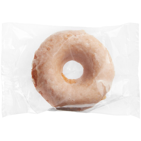 An individually wrapped Southern Roots Original Glazed cake donut in plastic.