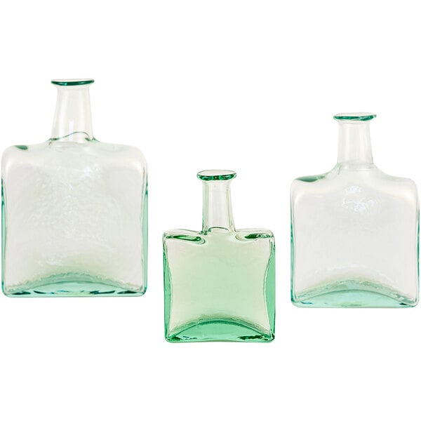 A group of clear glass bud vases with a white cap.