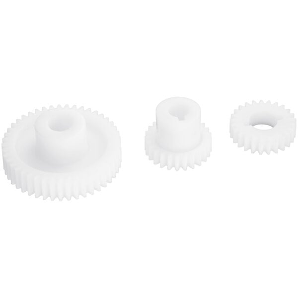 Three white plastic gears with a hole in the middle.