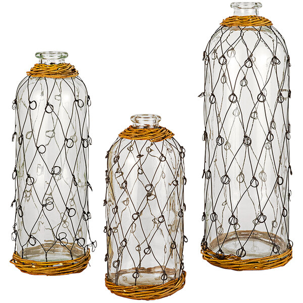 A group of three Kalalou glass vases with wire and wicker accents.