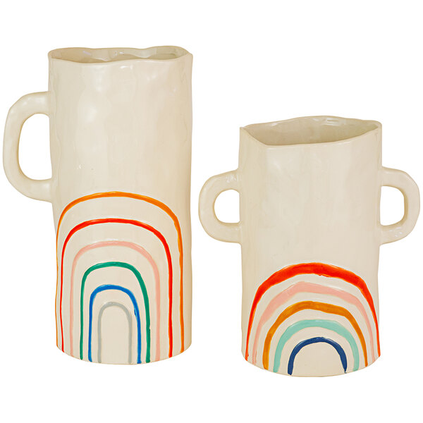 A pair of white vases with rainbow designs on them.