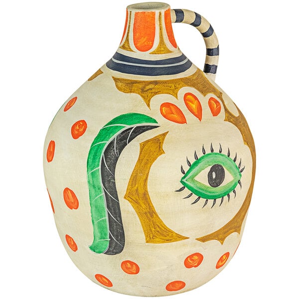 A white ceramic jug with a painted green eye and black snake.