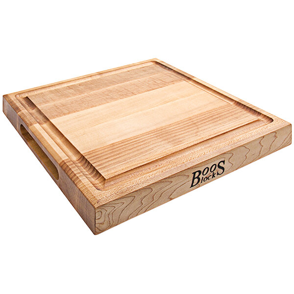 A John Boos maple wood cutting board with grooved handles.