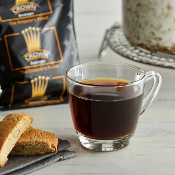 A glass mug of Crown Beverages Emperor's Finest coffee next to a bag of coffee.