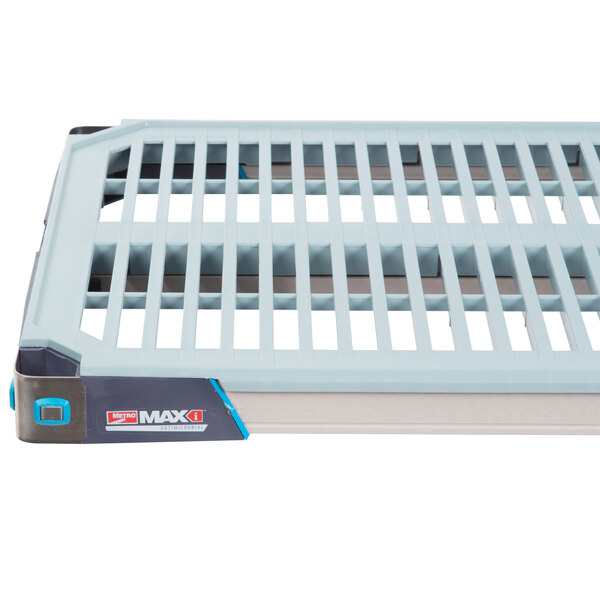A white plastic MetroMax i open grid shelf with a grey and white plastic removable mat on top.