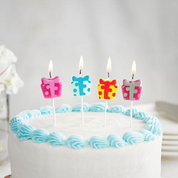 A white cake with Creative Converting present candles on top.