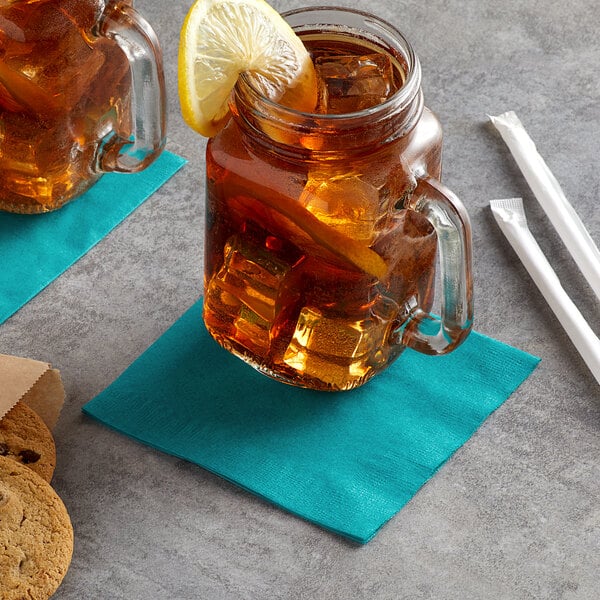 A glass mug with a Choice teal beverage napkin and a lemon slice on the rim.