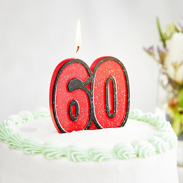 A white birthday cake with a red glitter "60" candle on top.