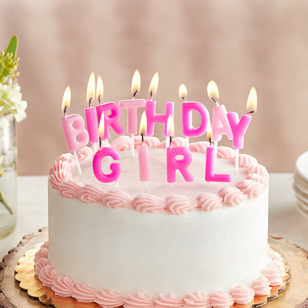 A white birthday cake with pink frosting and "Birthday Girl" candles on top.