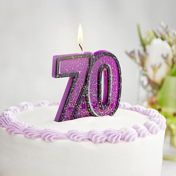 A purple Creative Converting "70" candle on a cake.