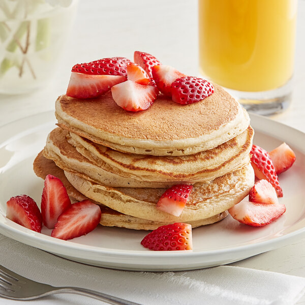 A stack of Kodiak Cakes Gluten-Free Frontier Oat Flapjacks with strawberries on top.