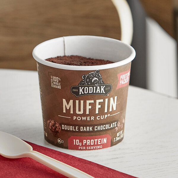 A Kodiak Cakes double dark chocolate muffin cup on a table.