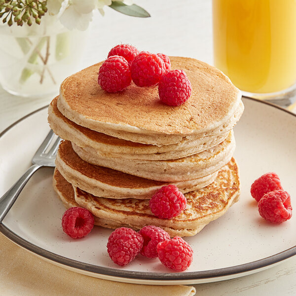A stack of Kodiak Cakes buttermilk pancakes with raspberries on top.
