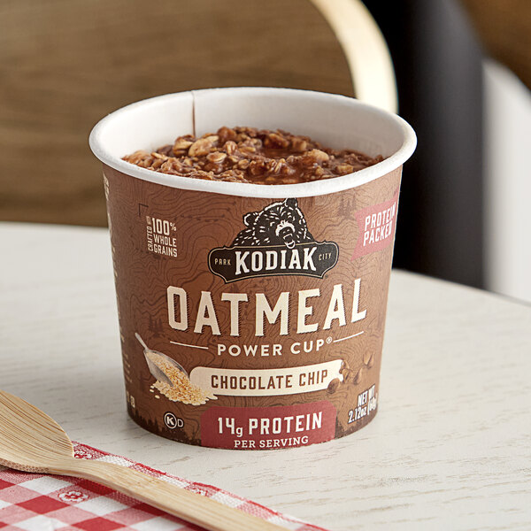 A close up of a Kodiak Cakes Chocolate Chip Oatmeal Power Cup on a table with a checkered tablecloth.