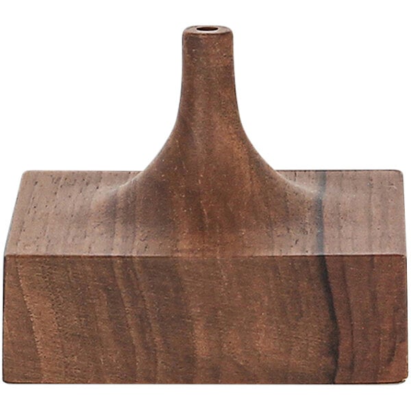 A wooden square stand with a pointy top and a hole.