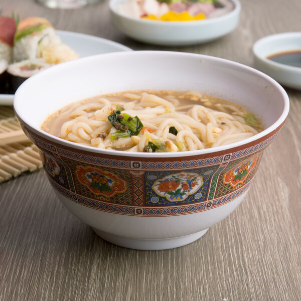 A bowl of Thunder Group Peacock melamine noodle soup on a table with sushi.
