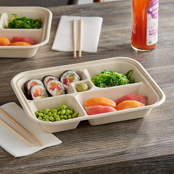 A World Centric compostable fiber bento box filled with sushi on a table.