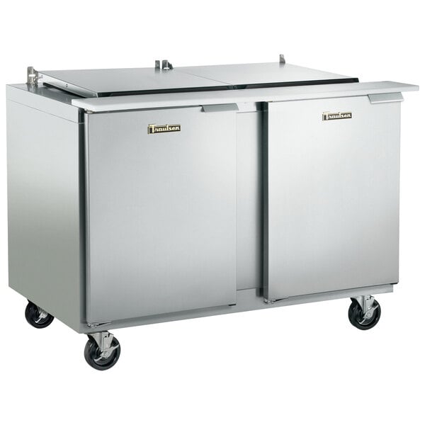 A Traulsen stainless steel refrigerated sandwich prep table with 2 left hinged doors on wheels.