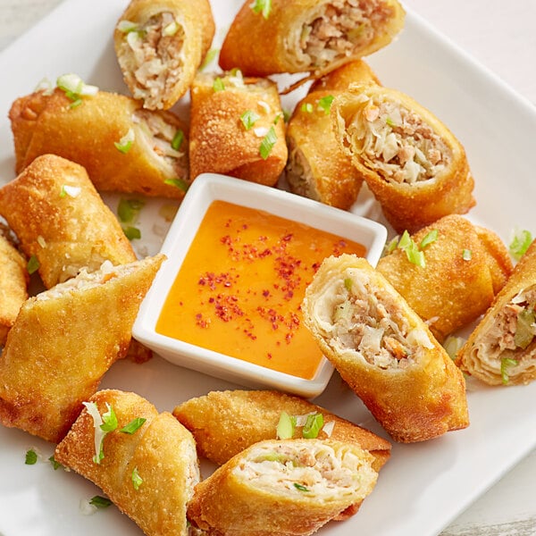 A plate of The Gourmet Egg Roll Co. chicken and vegetable egg rolls with dipping sauce.