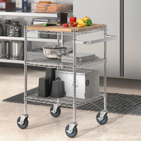 A Regency chrome utility cart with wooden shelves holding a metal container of vegetables.